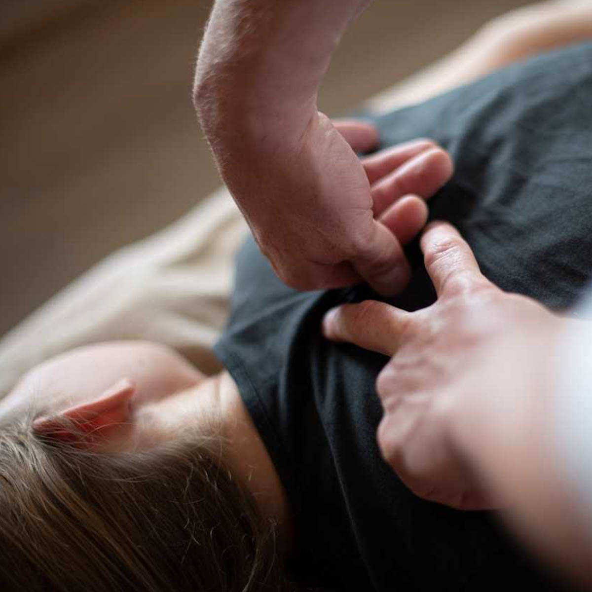 Treatment is being applied to a woman's shoulders to help relieve pain.