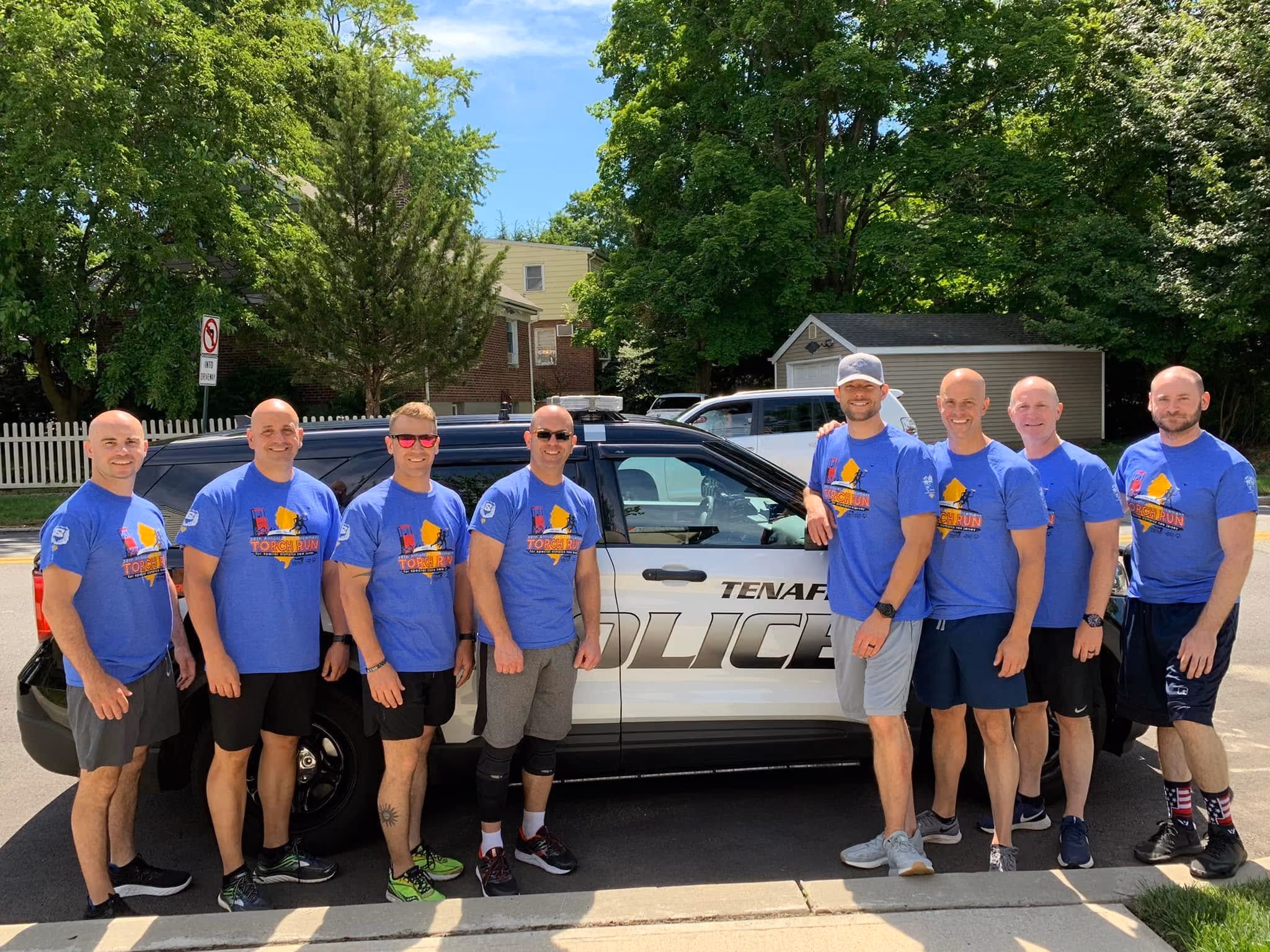 Tenafly PD officers in charity t-shirts smiling group photo