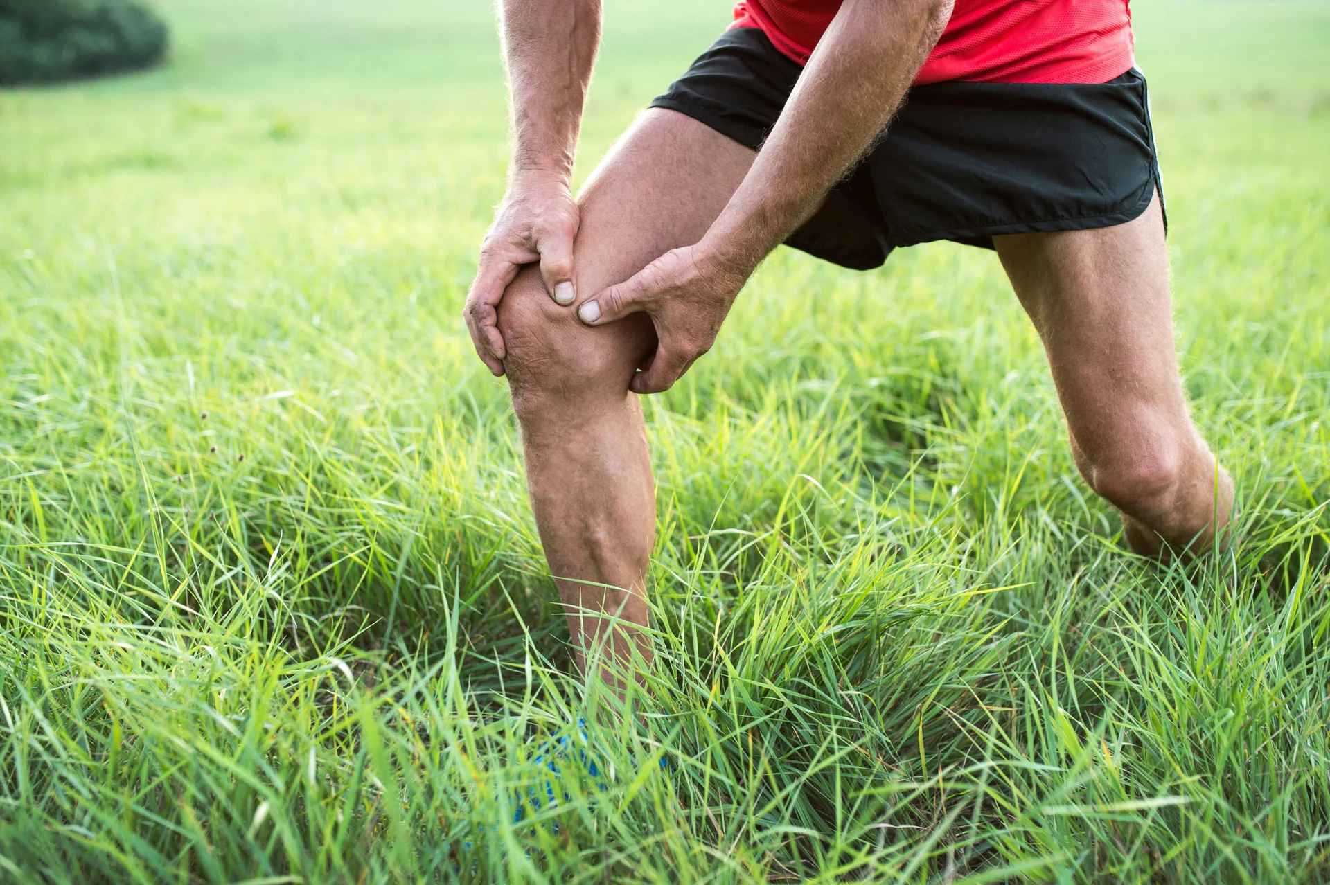 Runner holding a sore knee outdoors