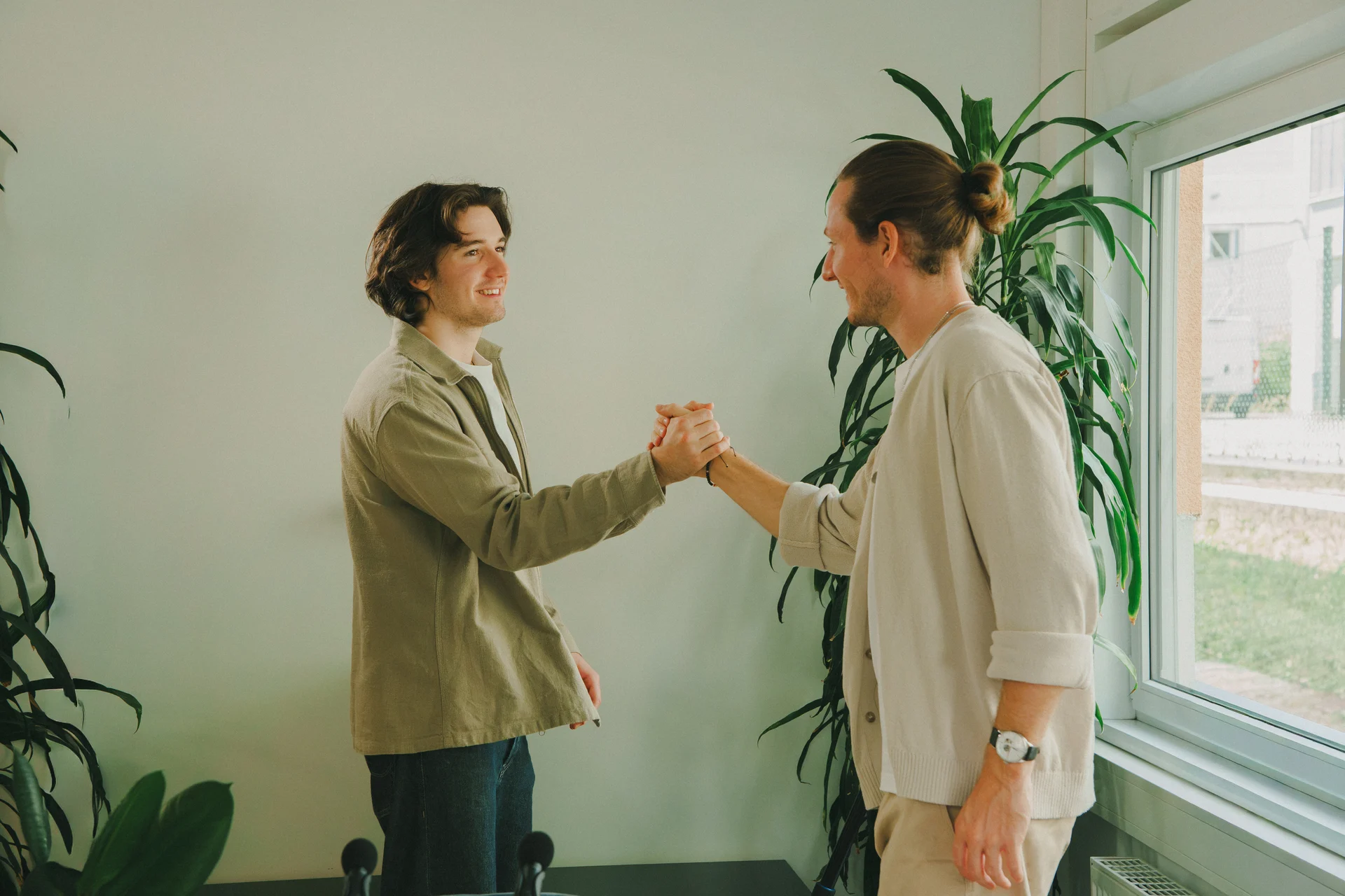 Zwei Personen geben sich im Büro die Hand