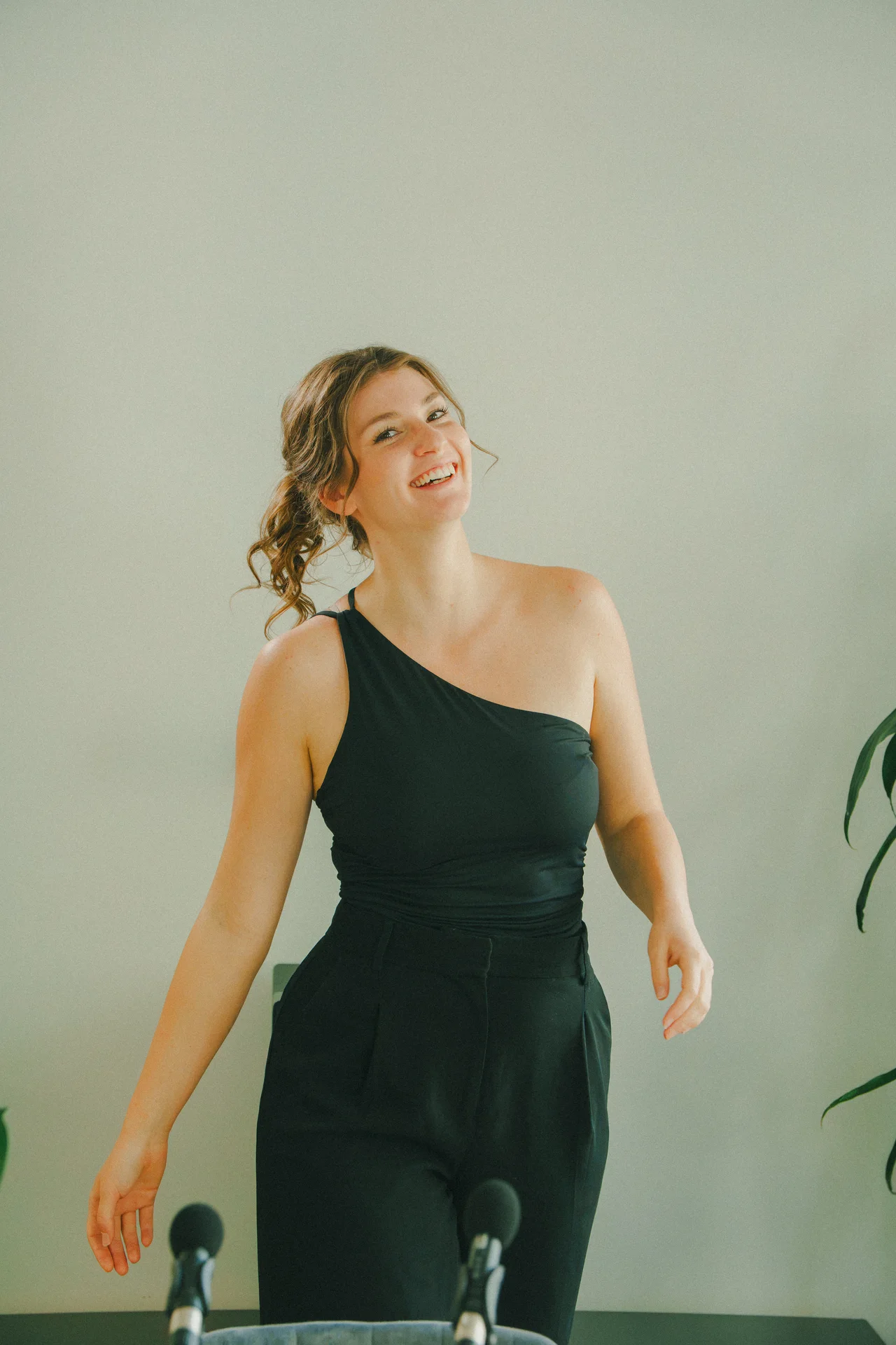 Lachende Frau aus dem Mindspace-Team vor zwei Mikrofonen