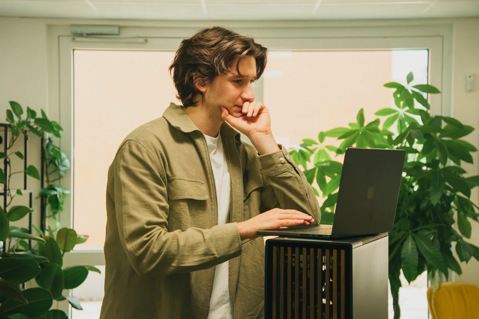 Mitarbeiter arbeitet am Laptop neben einem lokalen KI-Server im Büro