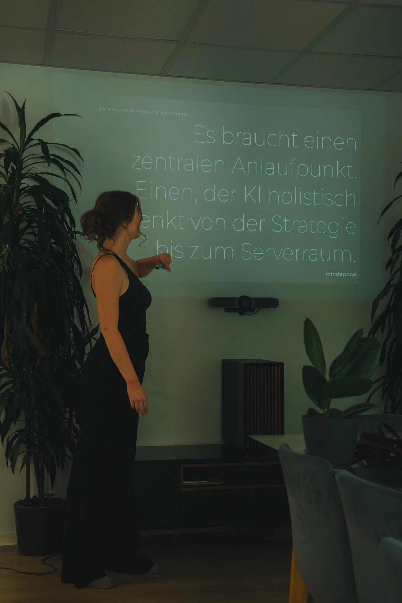 Eine menschliche Hand berührt die Wasseroberfläche, darunter spiegelt sich eine digitale Hand – KI, die dem Menschen dient.