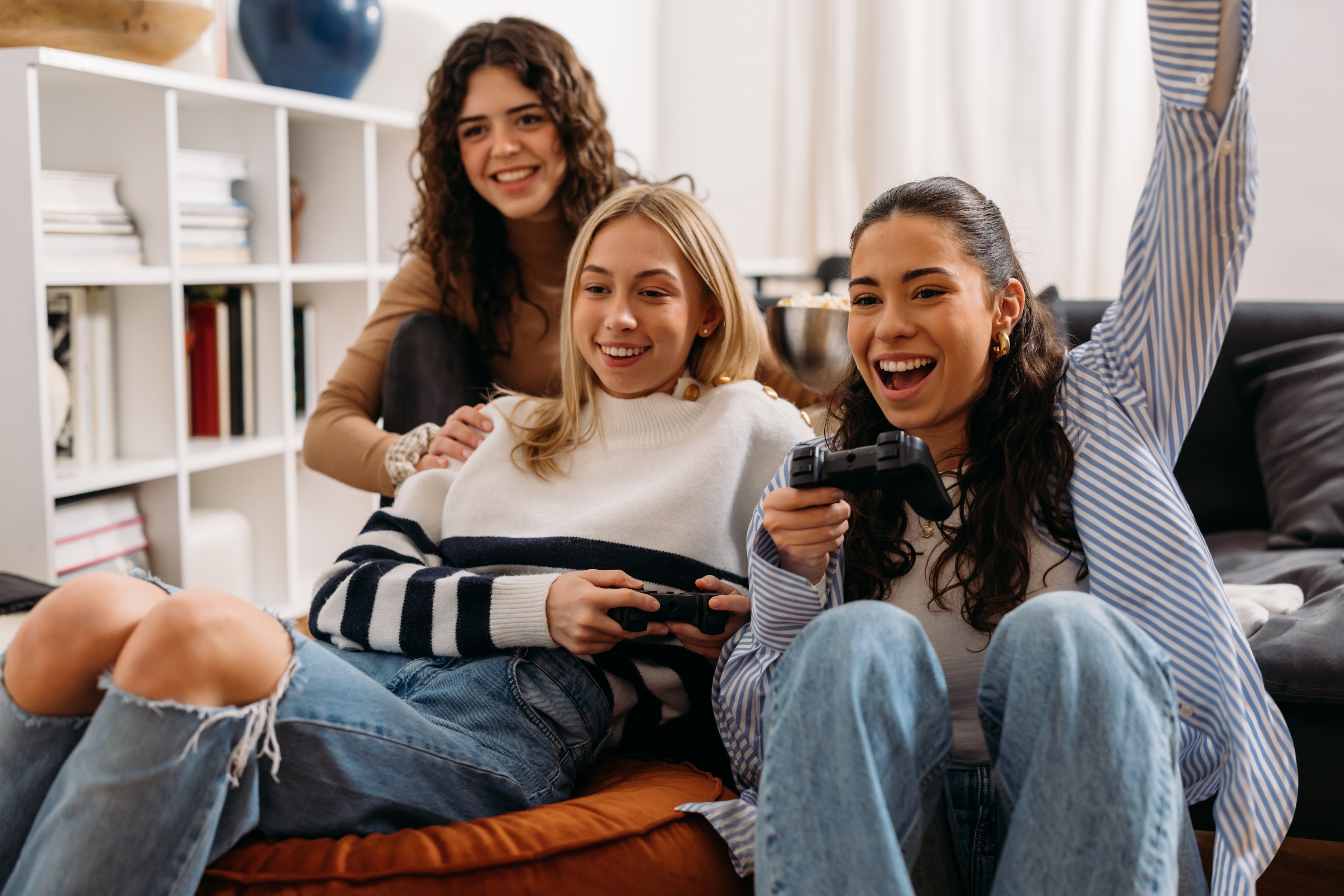 Girls playing video games on couch stock image