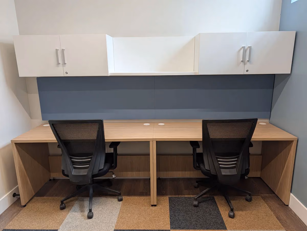 A private office space with two desks joined together.