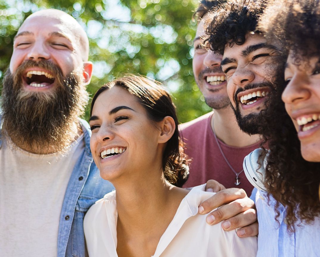 Four friends laughing together outdoors