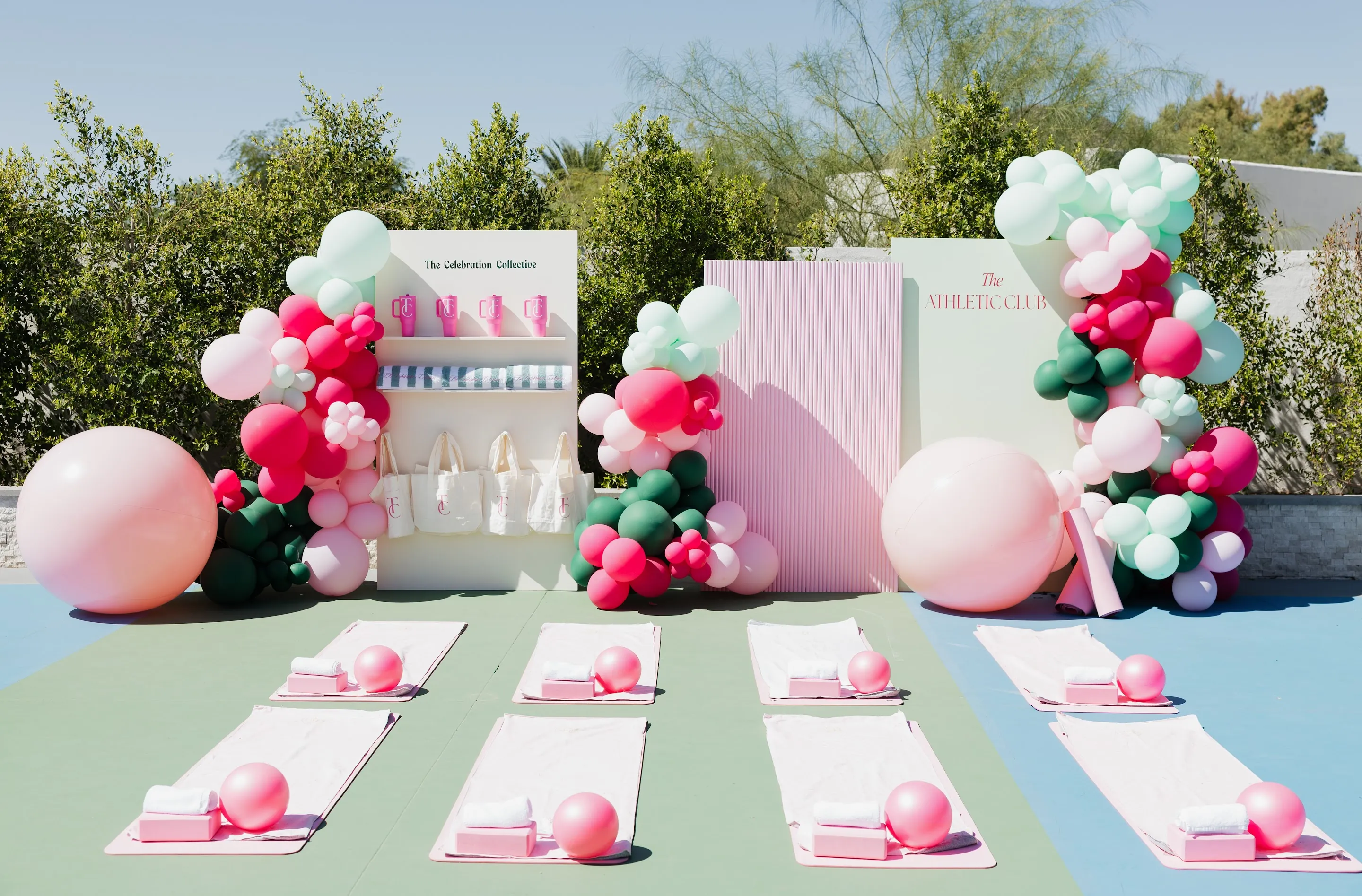 Pink, mint and green balloon garlands around branded backdrops at The Athletic Club activation
