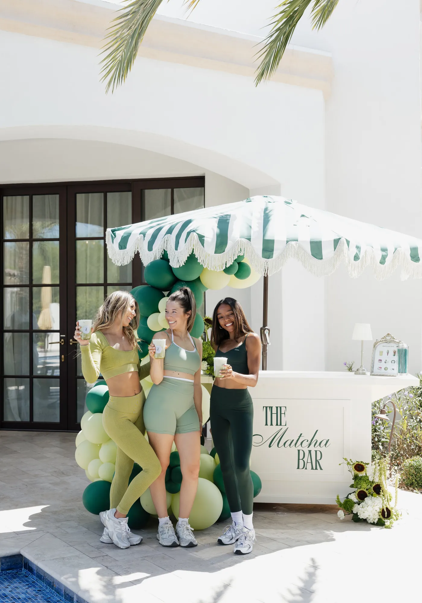 Three guests holding matcha drinks at The Matcha Bar cart