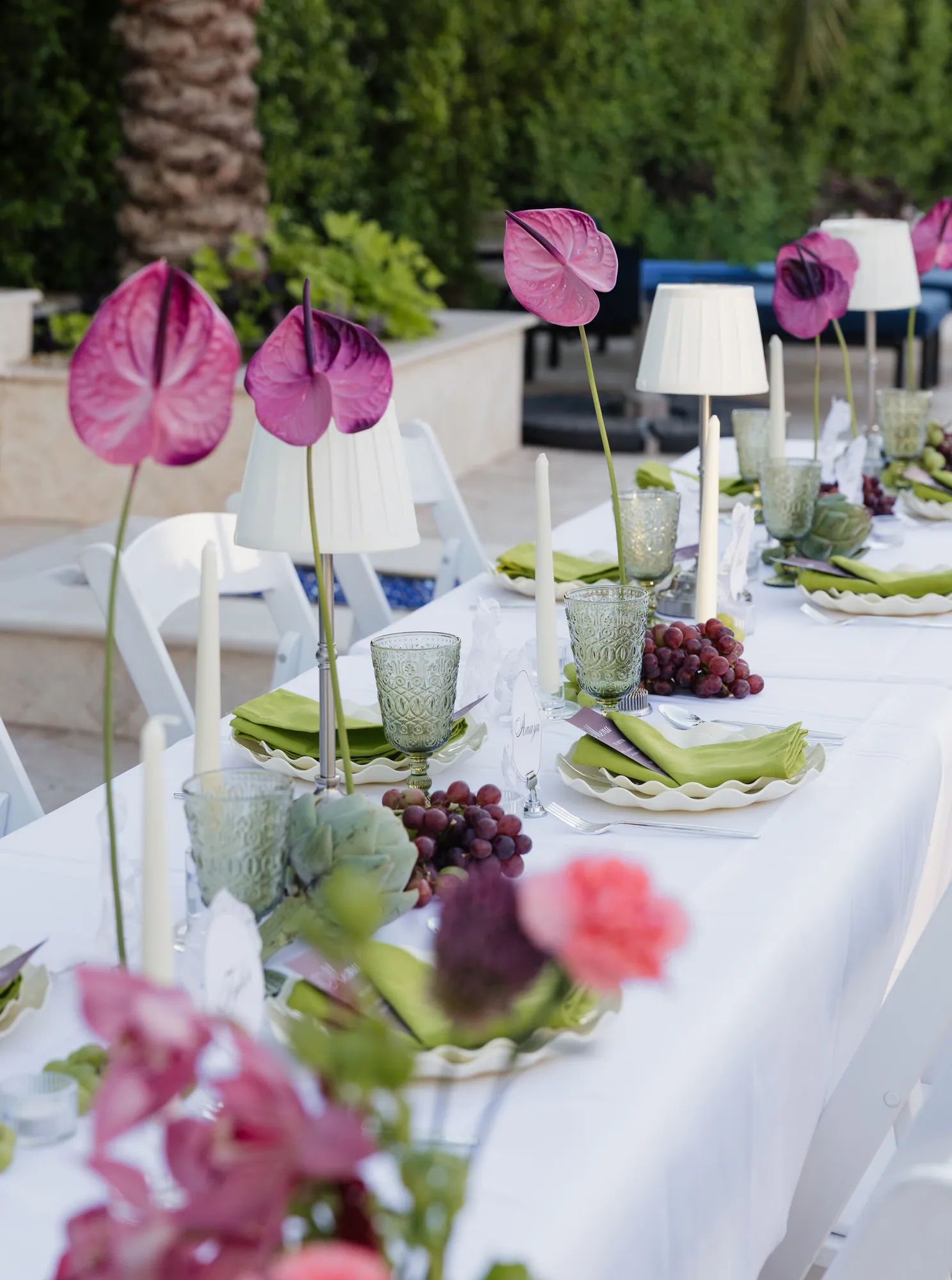 Tablescape with anthuriums, table lamps and green glassware