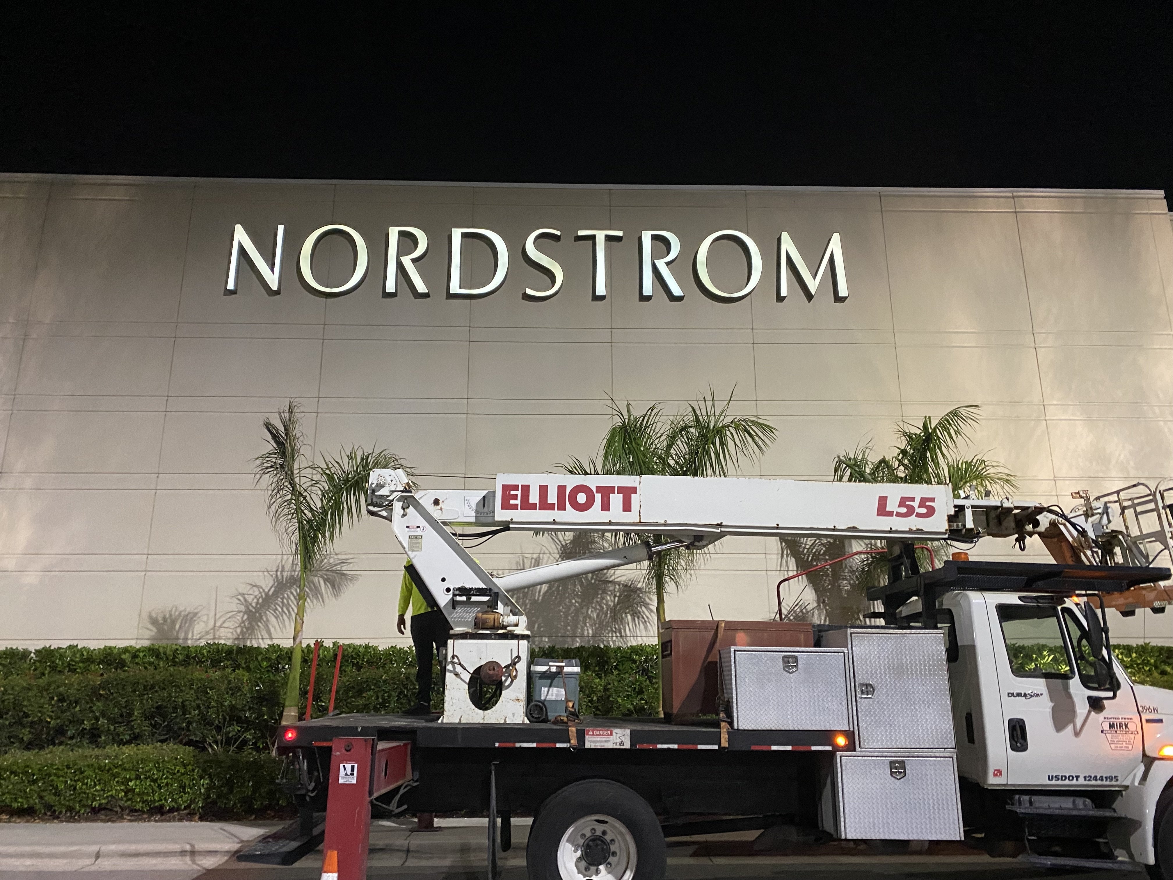 Illuminated Nordstrom channel letter storefront sign at night with TSI service crane truck