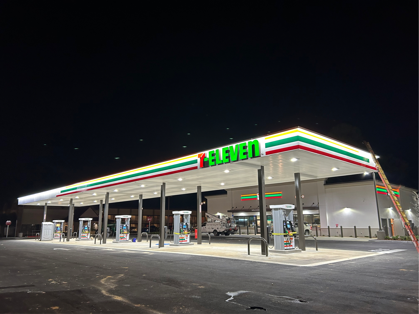 Nighttime 7-Eleven gas canopy with illuminated channel letters and brand LED fascia stripes
