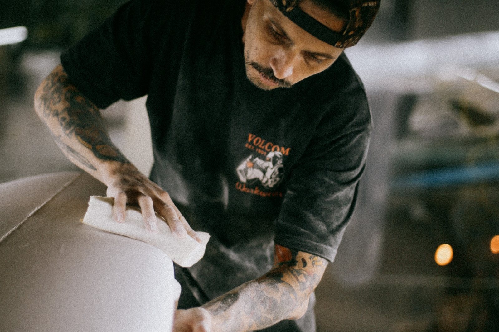 Mark Cormack of Nuevo Camino sanding a surfboard in the shaping bay at House of Somos