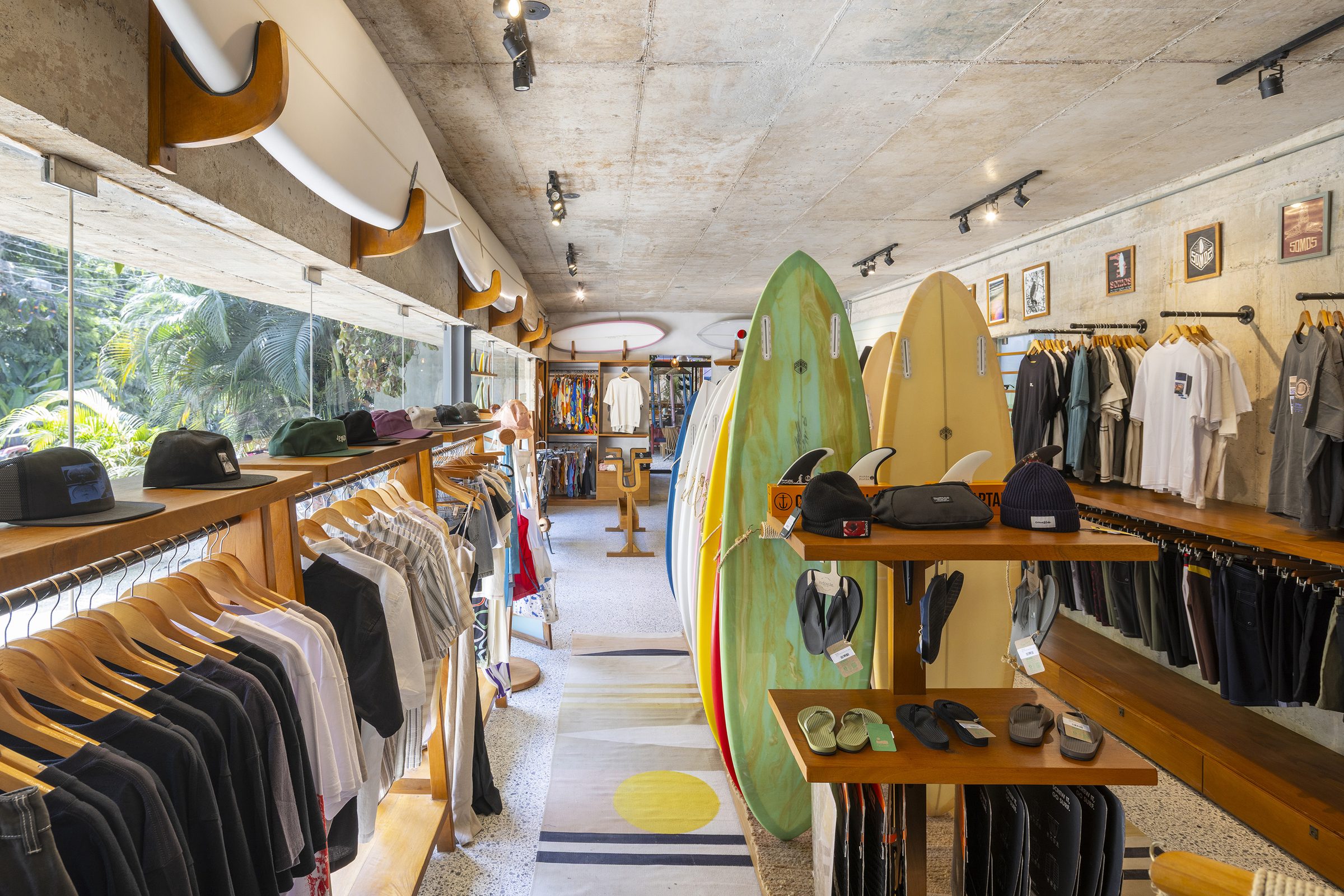 Inside the Somos shop with apparel racks and surfboards