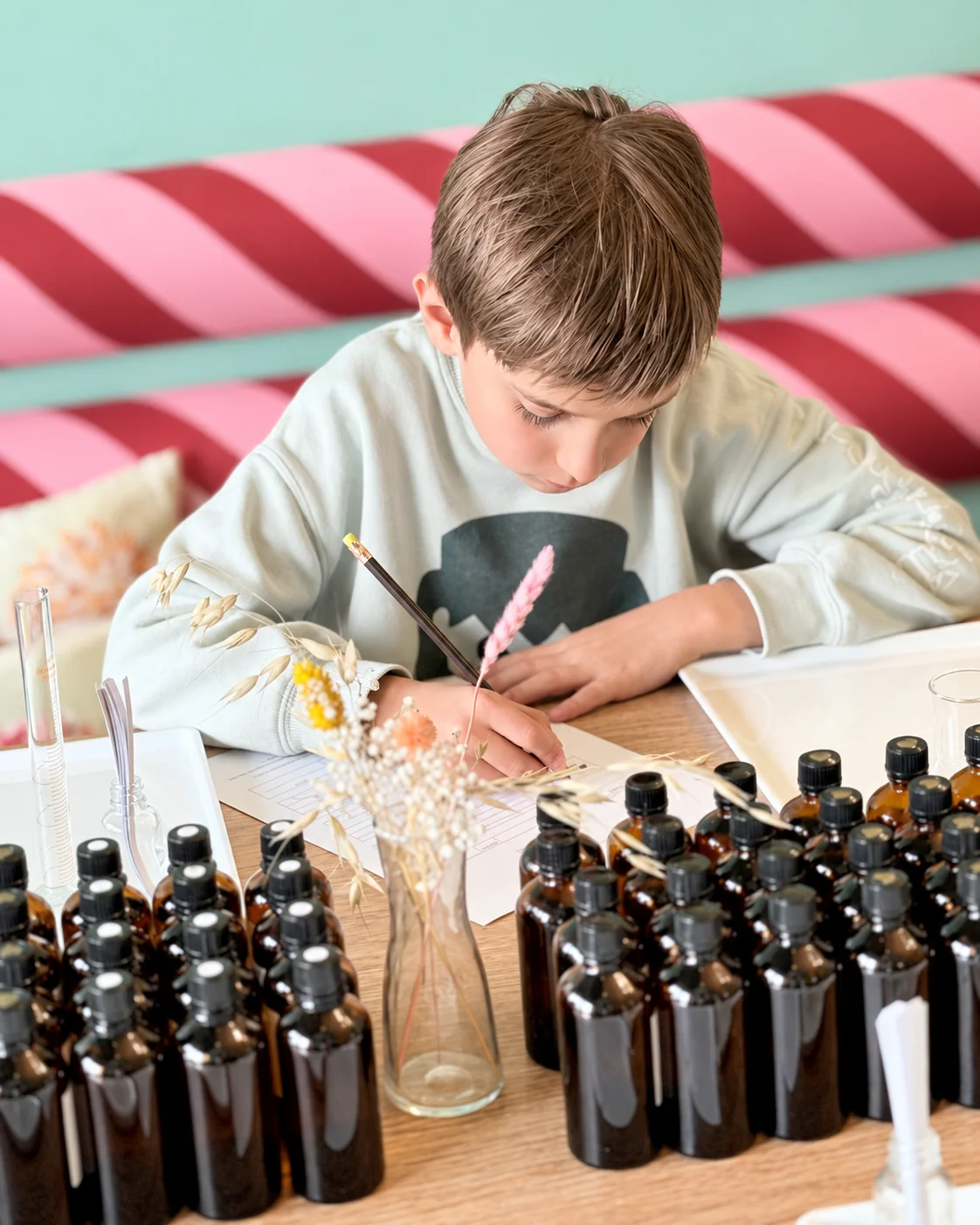 Ein junger Gast hält seine Duftideen im Hamburger Parfum-Atelier fest