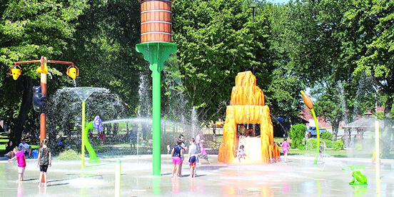 East Tennessee Attractions: Children running through water jets at a splash pad on a sunny day.