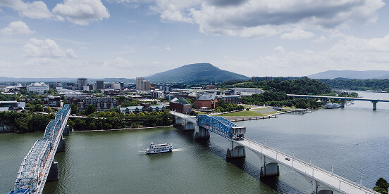 East Tennessee Attractions: Downtown Chattanooga from the air, with its bridges over the Tennessee River and a riverboat mid-channel.
