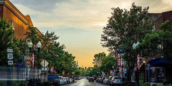 East Tennessee Attractions: A small-town main street at dusk, with brick storefronts and banners on the lampposts.