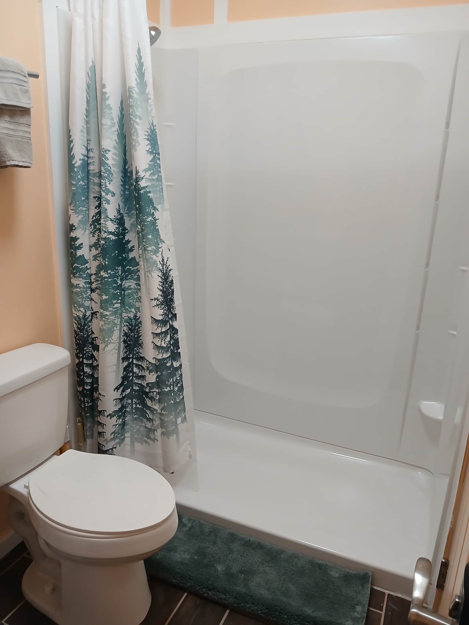 Vacation Rentals in Tennessee: A bathhouse shower and tub behind a pine tree shower curtain, next to the toilet.