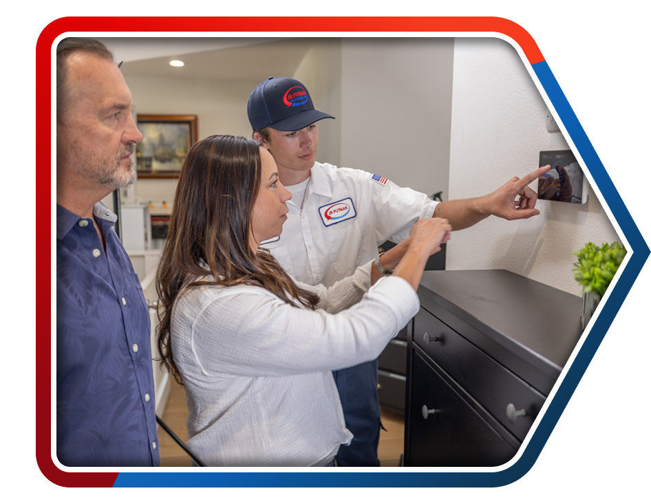 A JR Putman technician helping homeowners with their thermostat