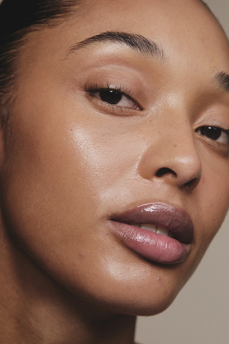 Close-up of a woman's face with smooth, glowing skin and natural makeup.