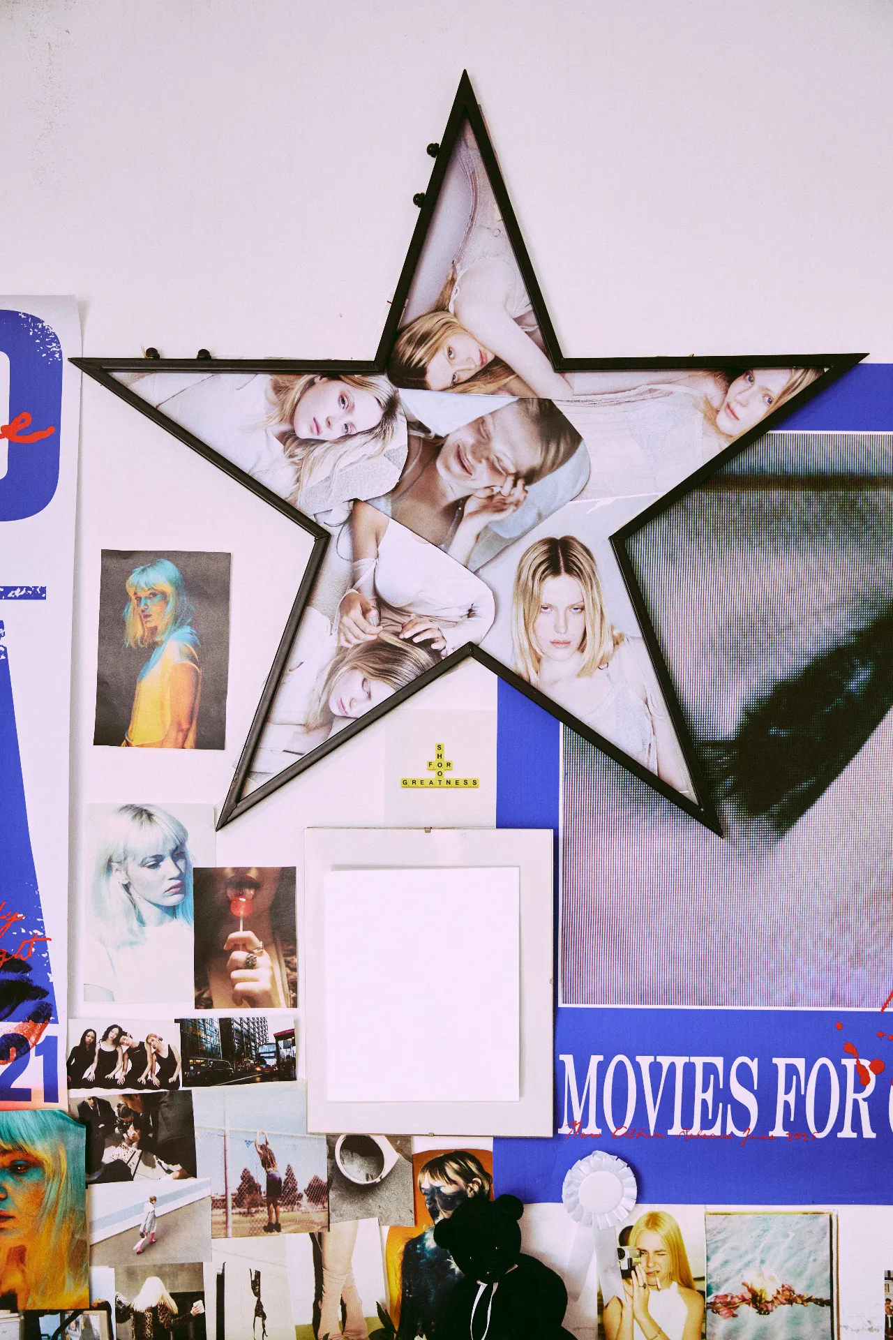 A star-shaped black frame hangs on a collage-covered wall, filled with overlapping photographs of the same young woman in different poses. Surrounding it are colorful fashion images, portraits, posters, and other magazine-style clippings.