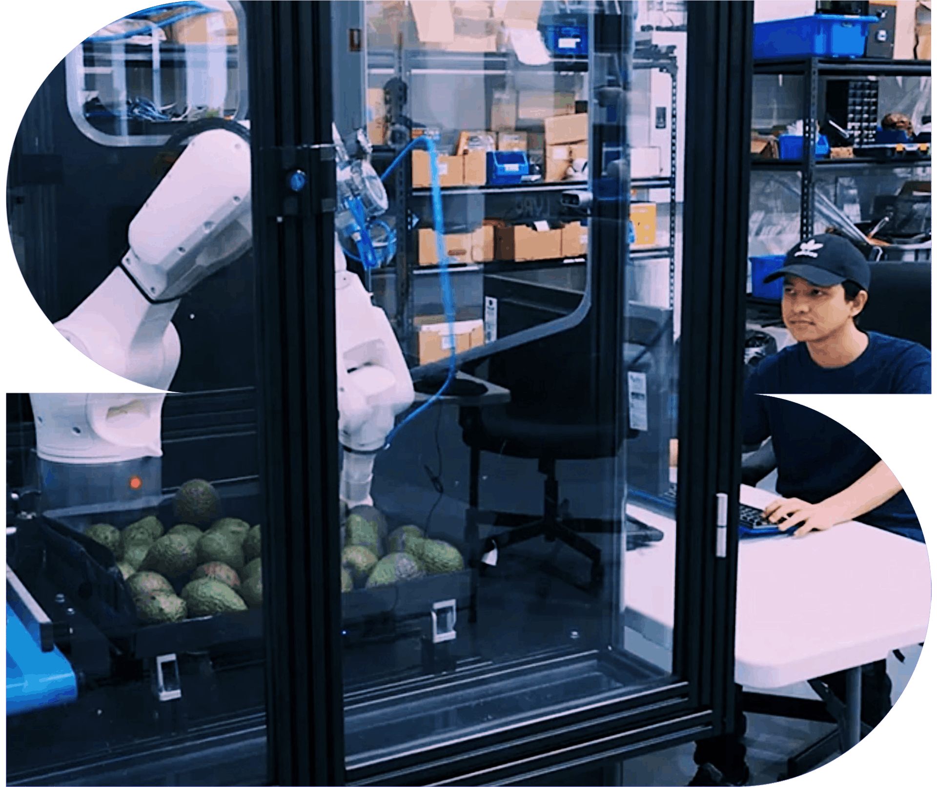 A man sits outside a contained robotics unit driving the robotic arm to complete an action.