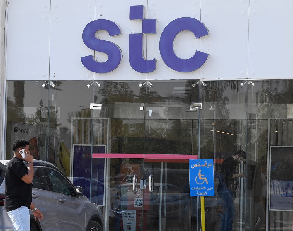 a man walking in front of an stc store
