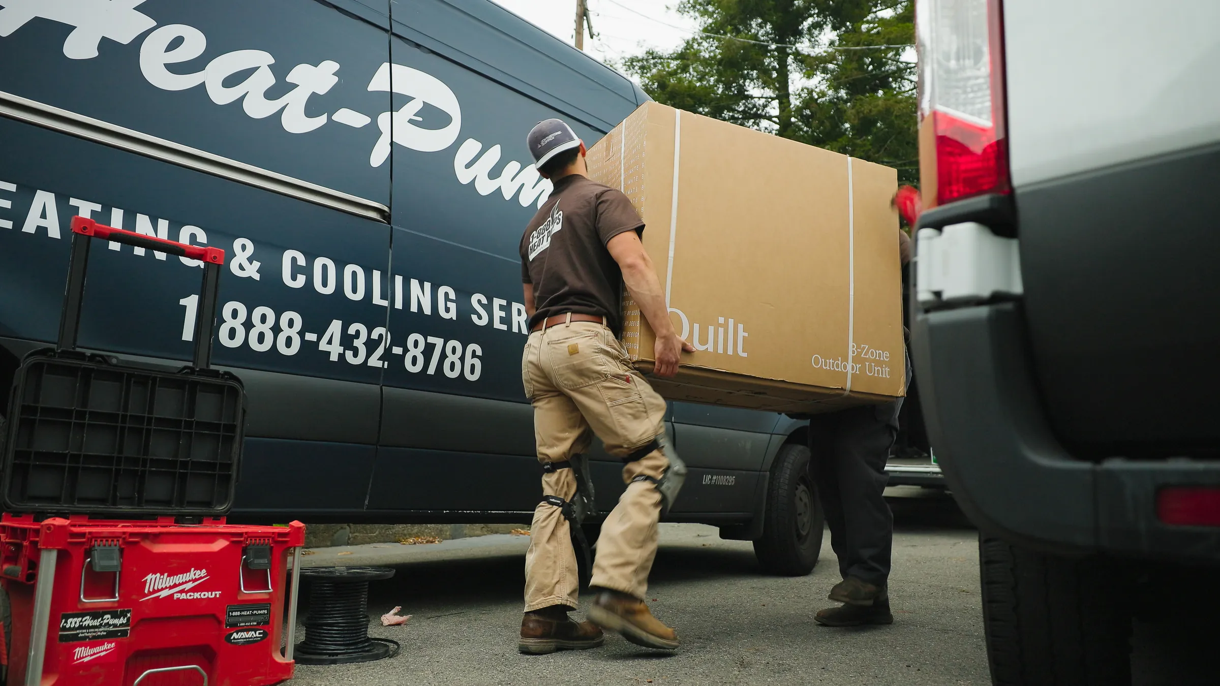 1-888-Heat-Pumps crew unloading a new heat pump from the company van