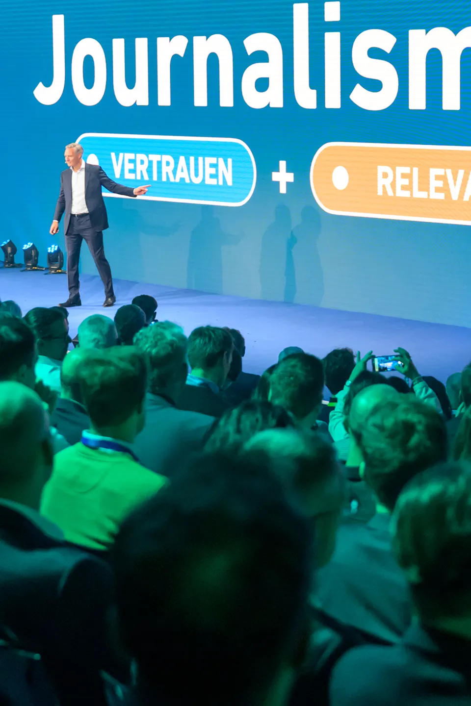 Gäste im Networking-Bereich vor der Partnerwand