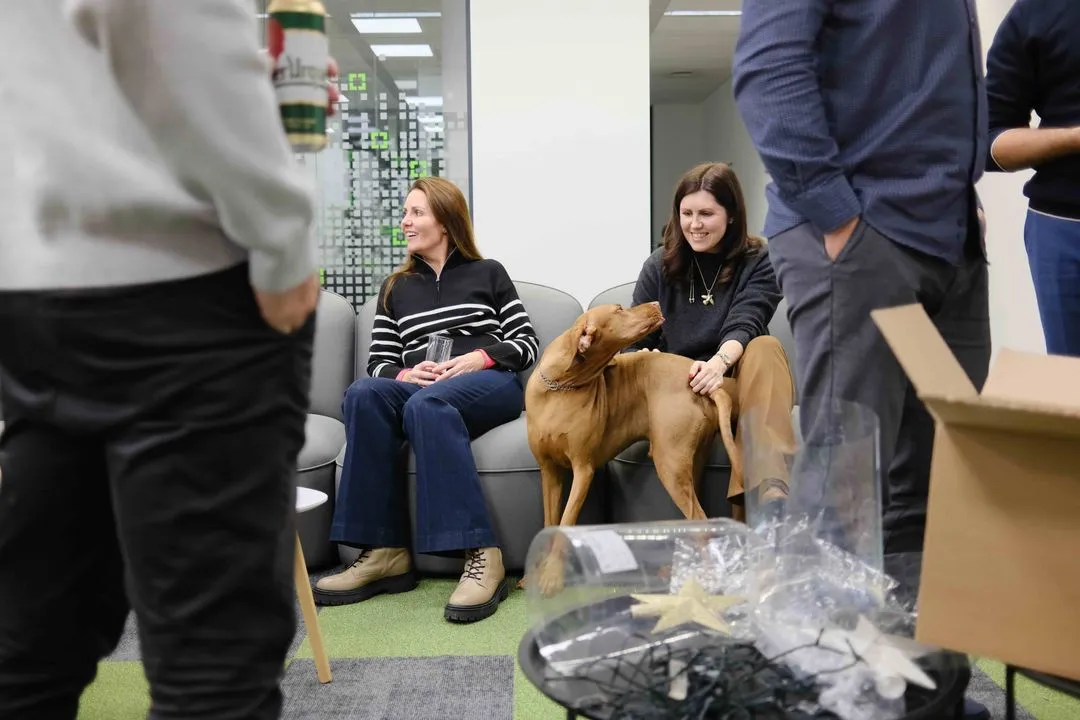 Dos compañeros de GoodVision y un perro de oficina en las instalaciones de GoodVision