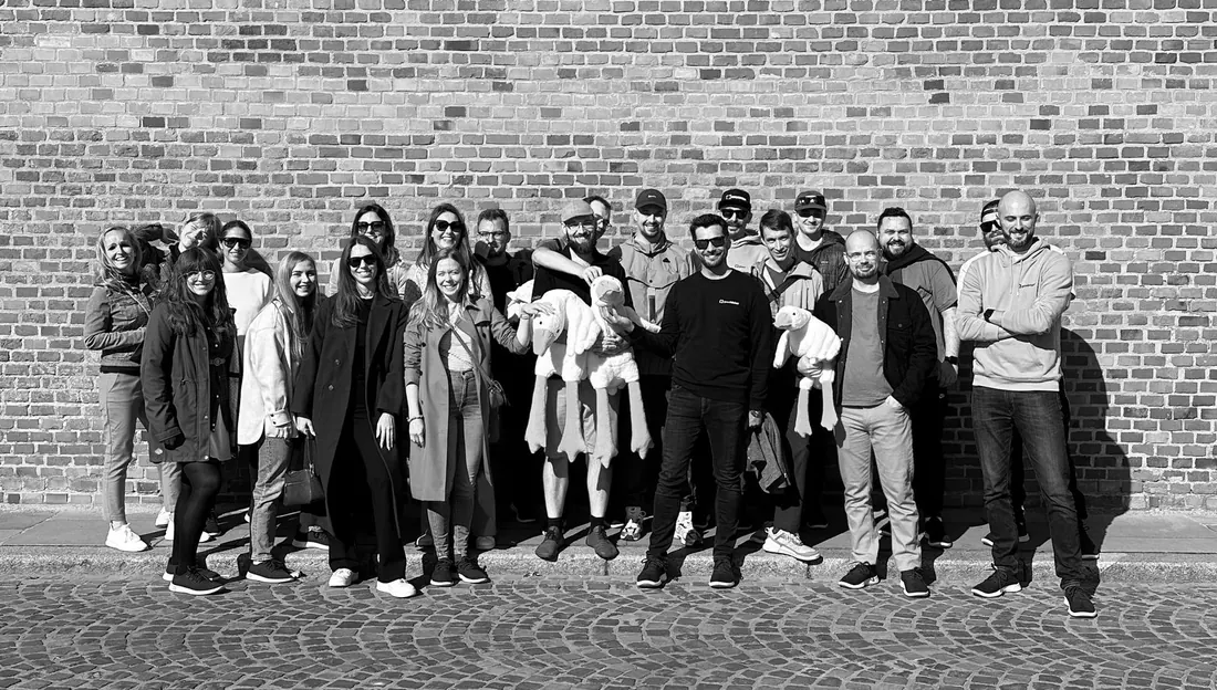 The GoodVision team standing together in front of a brick wall, in black and white