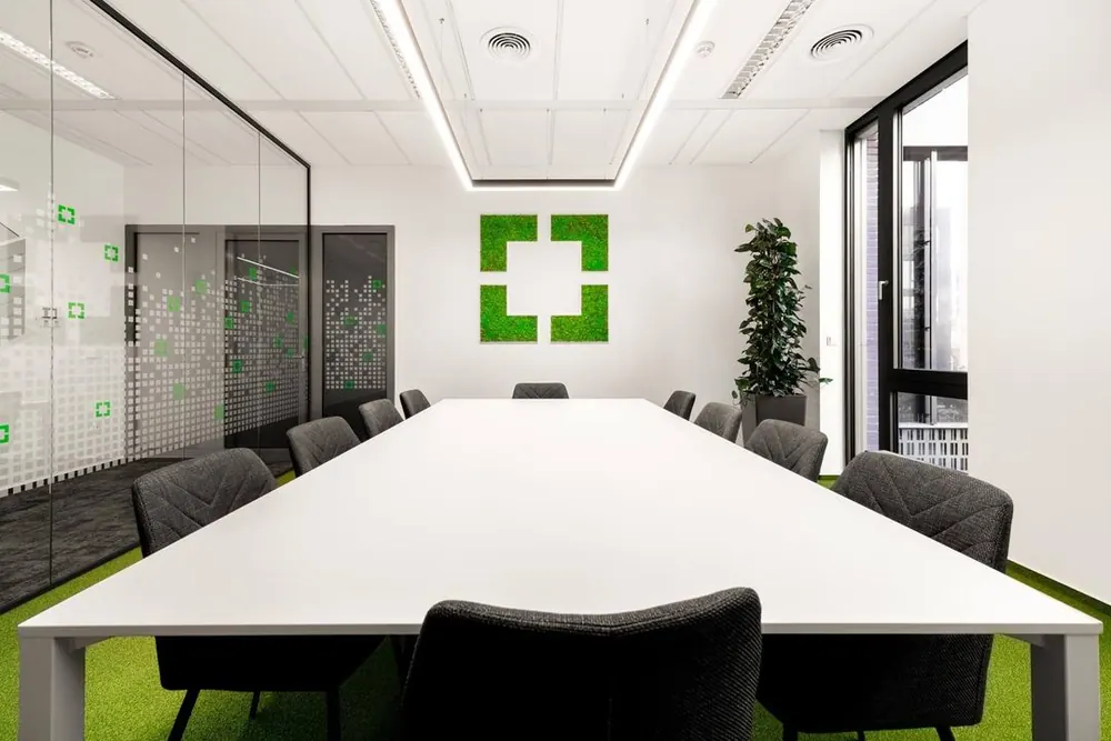 GoodVision meeting room with the GoodVision logo on a green moss wall