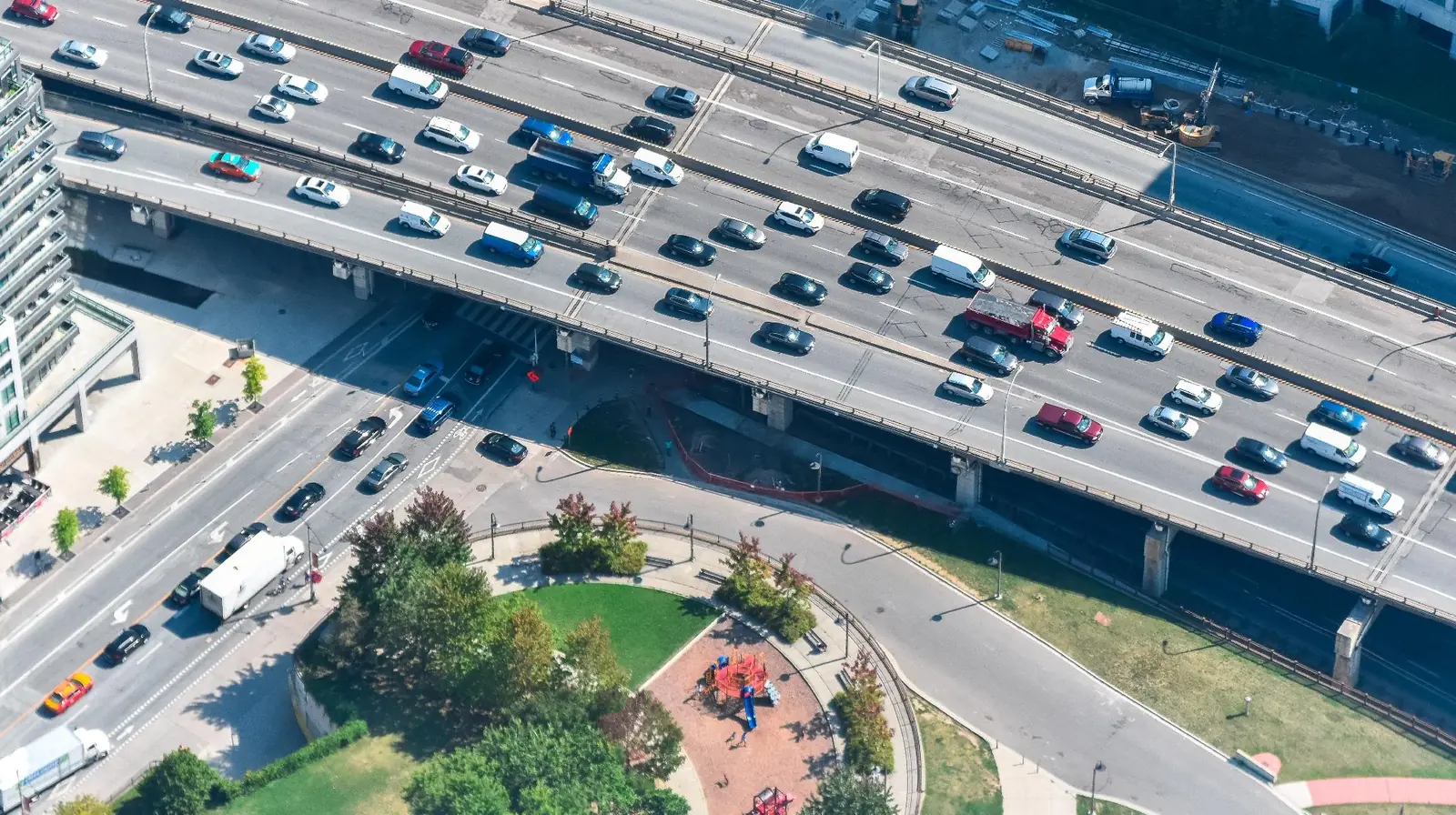 Aerial view of a multi-lane urban highway on a viaduct carrying heavy traffic in both directions