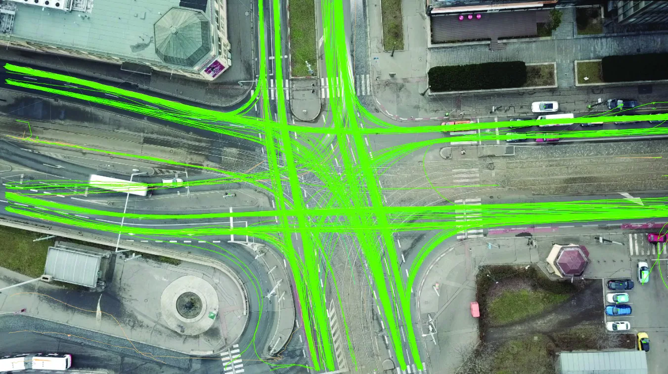 Aerial view of a junction beside a roundabout, with vehicle trajectories for every movement drawn in green