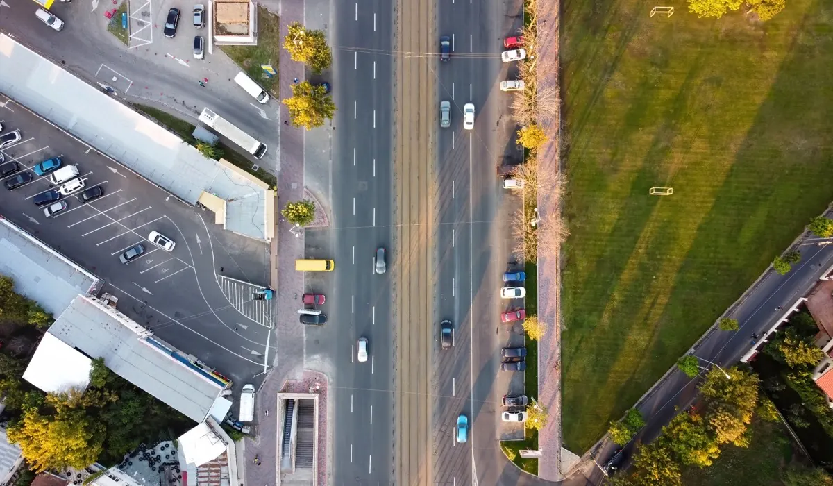 Vista aérea de un corredor vial urbano con estacionamientos a los lados