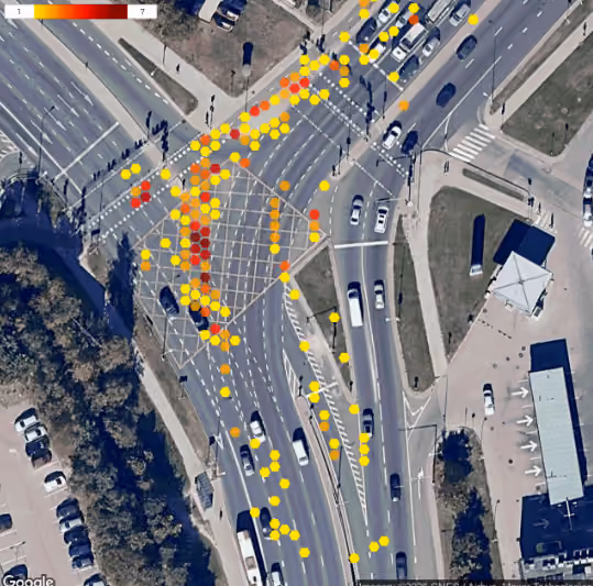 Drone view of a busy junction approach in GoodVision Video Insights, with cars, buses and pedestrians labeled and one interaction marked in red
