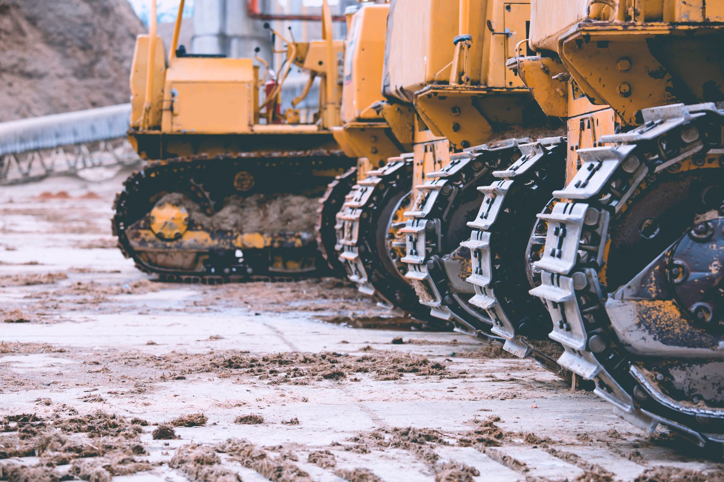A row of tracked heavy machines on a dealer lot