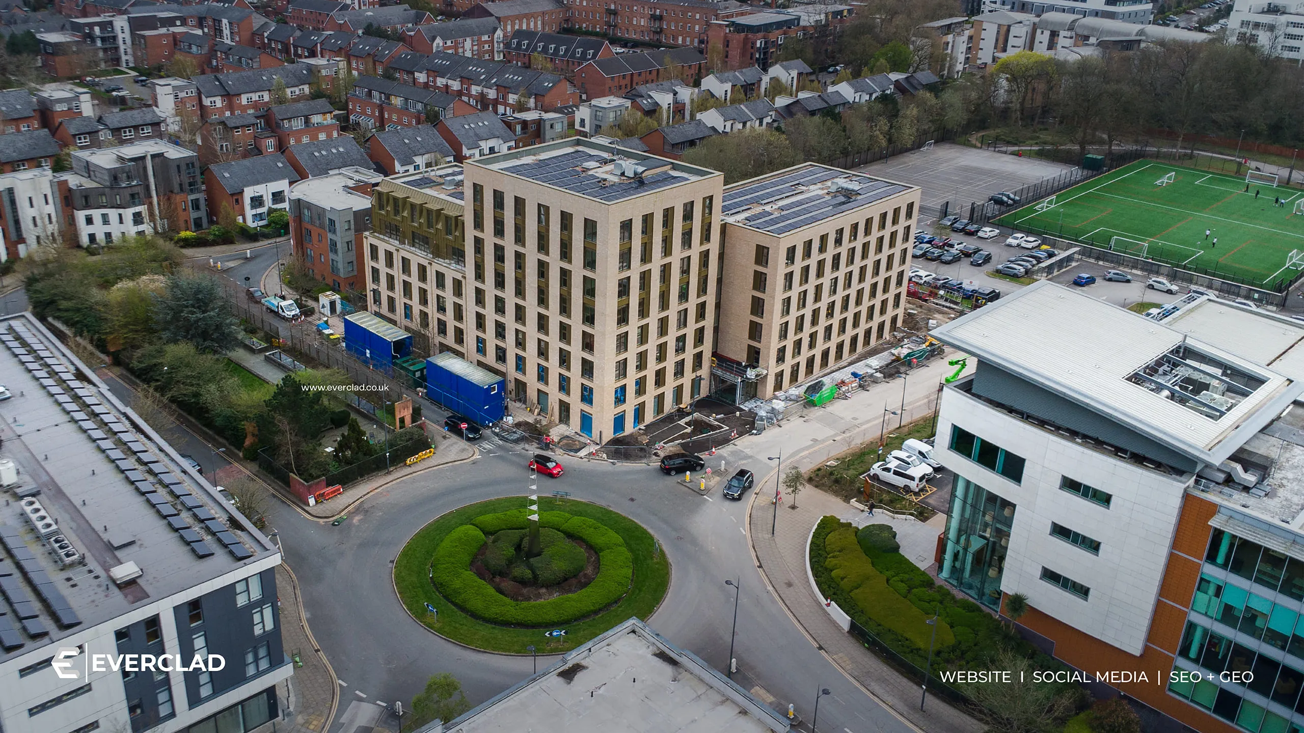 Everclad-clad buildings beside a roundabout, aerial view, website, social media and SEO + GEO by Just Chill