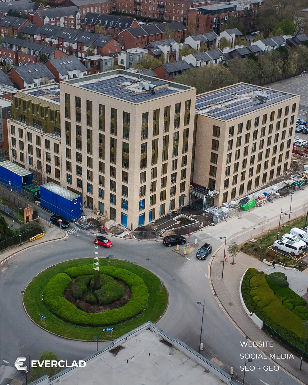 Everclad-clad buildings beside a roundabout, aerial view, website, social media and SEO + GEO by Just Chill