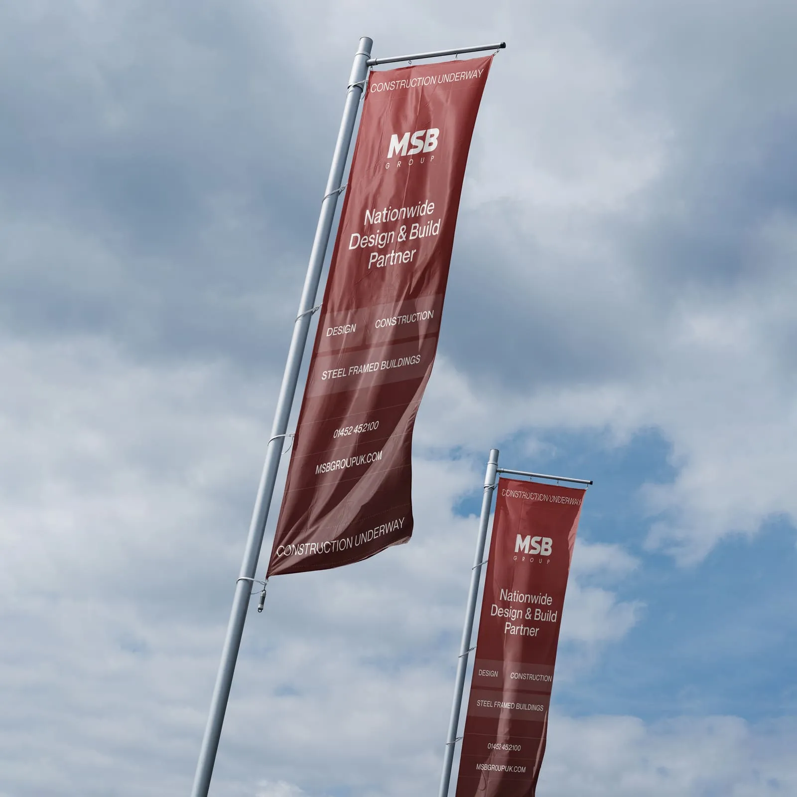 MSB Group red flags on tall flagpoles against a cloudy sky