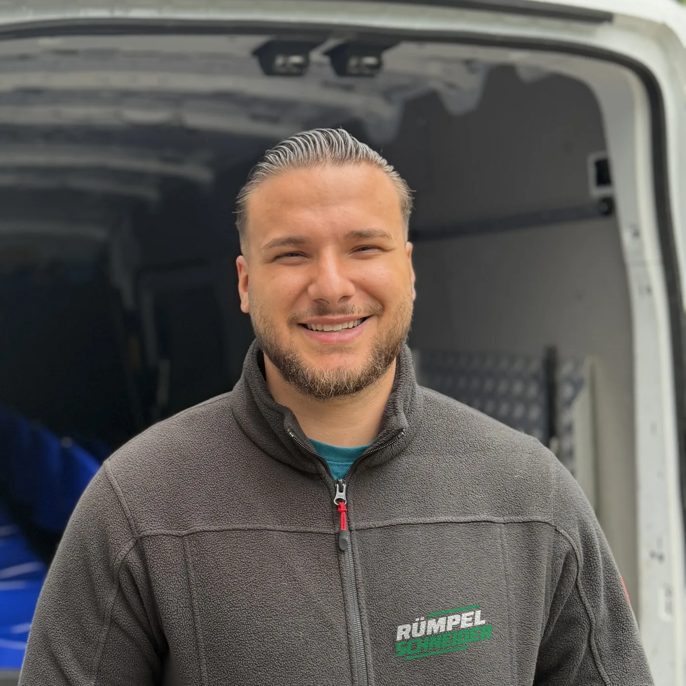 Riccardo Mancusi, Inhaber von Rümpel Schneider, vor dem offenen Firmenwagen