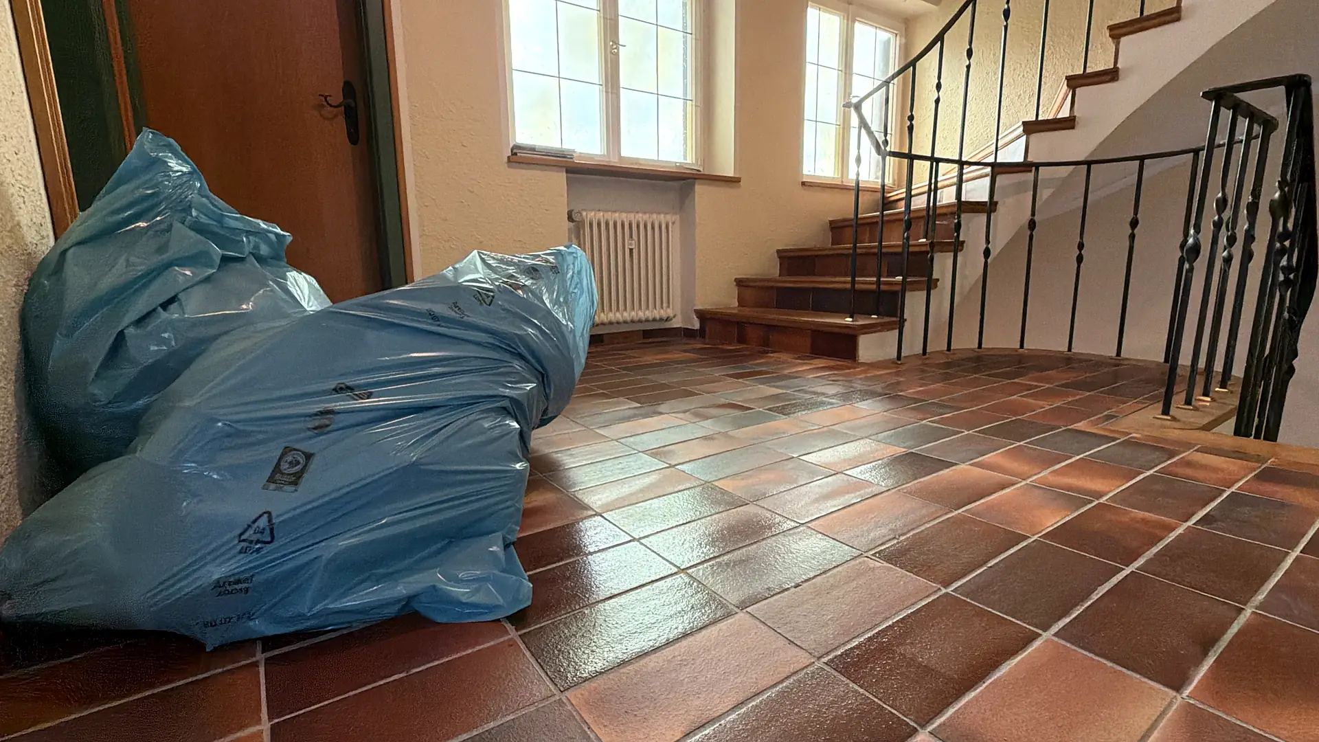 Hausflur während einer Räumung: gepackte Säcke am Fuß der Treppe