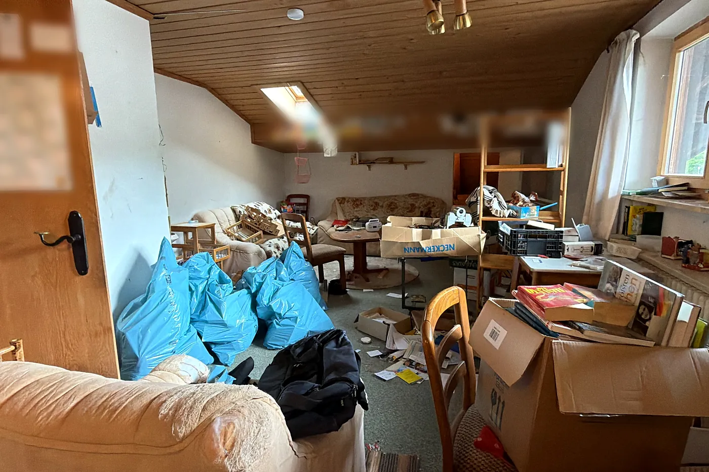 Dachgeschoss während einer Entrümpelung: Säcke, Kartons und Möbel