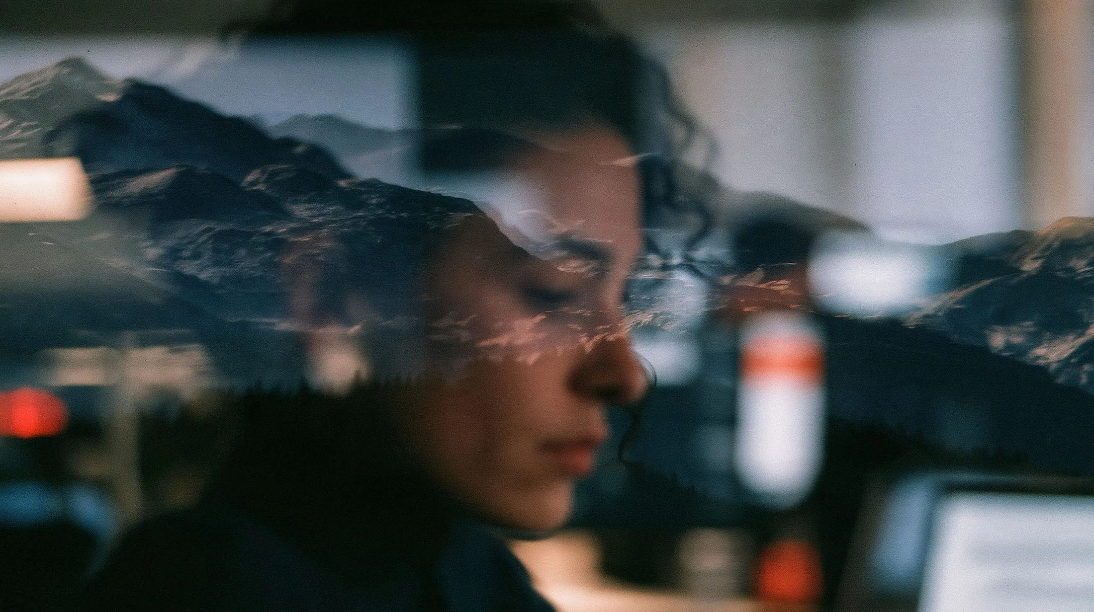 A person at work reflected in glass over a mountain