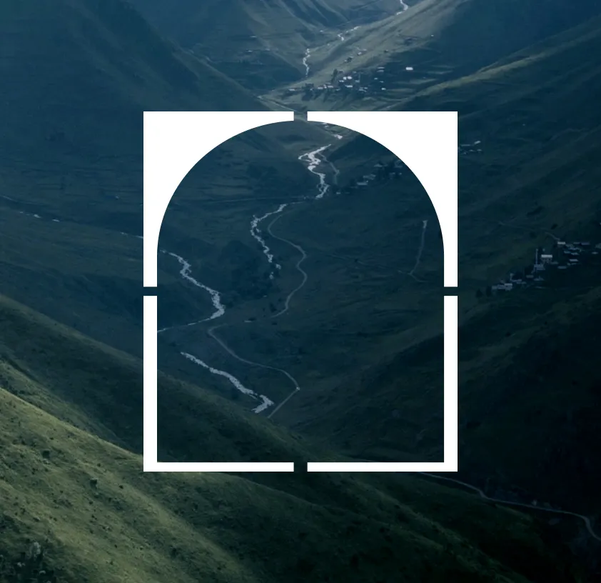 An aerial view of a glacier running between dark volcanic ridges