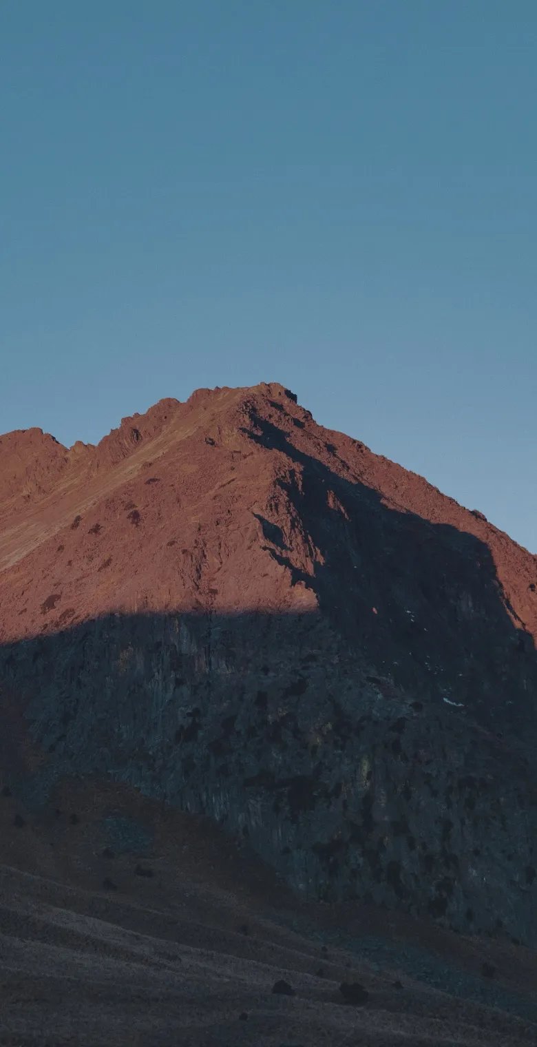 Sunlit mountain crest against a clear sky