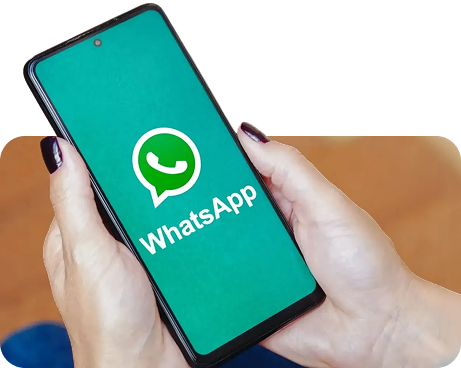 Mãos segurando um celular com o logo do WhatsApp na tela