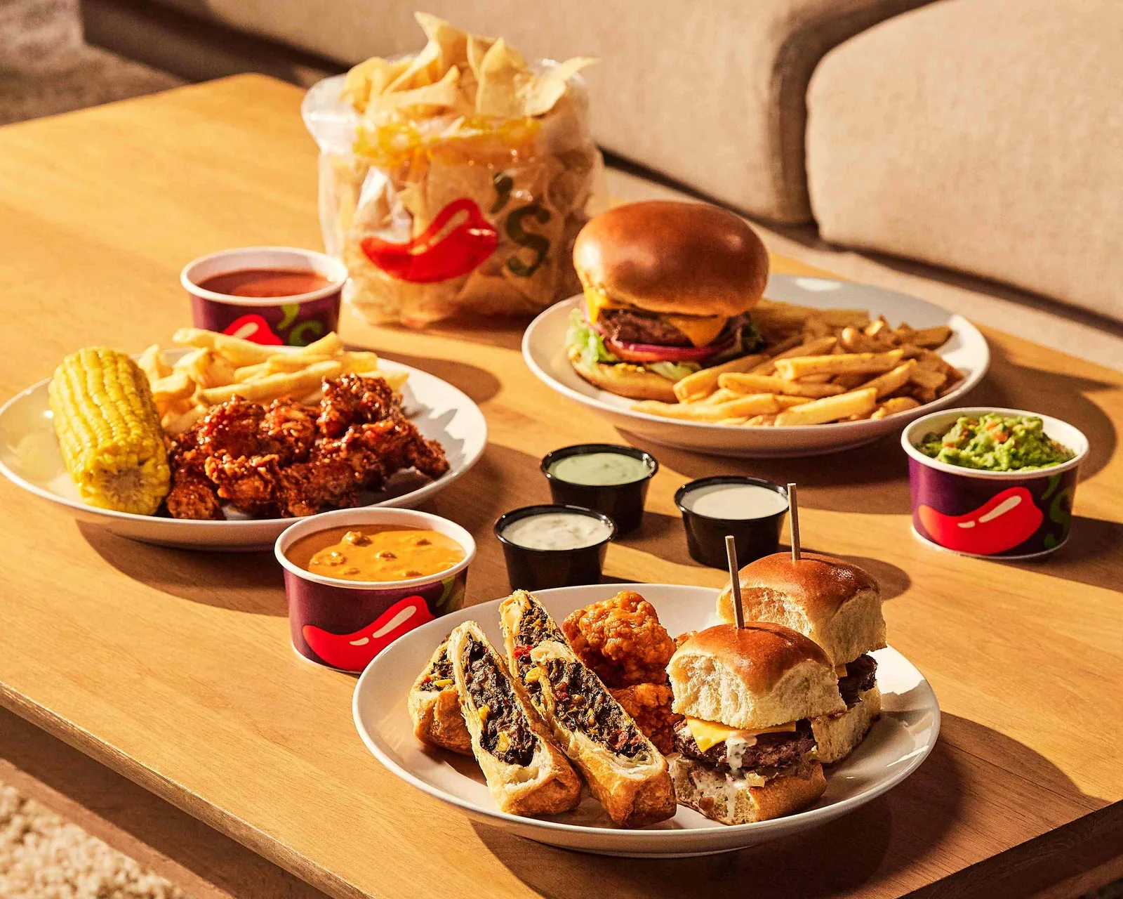 Chili's burger, fries, and appetizer platter spread on a table