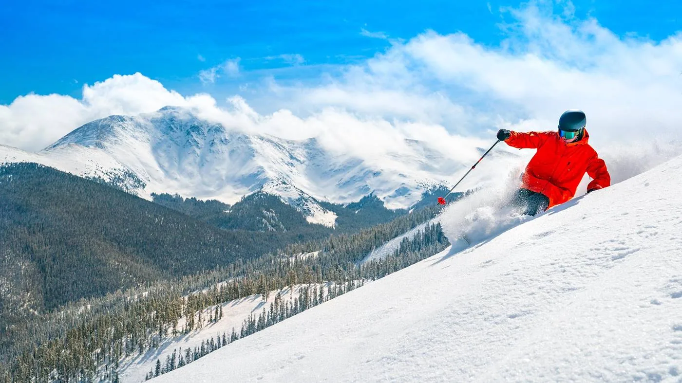 Skier carving through fresh powder at Winter Park Resort