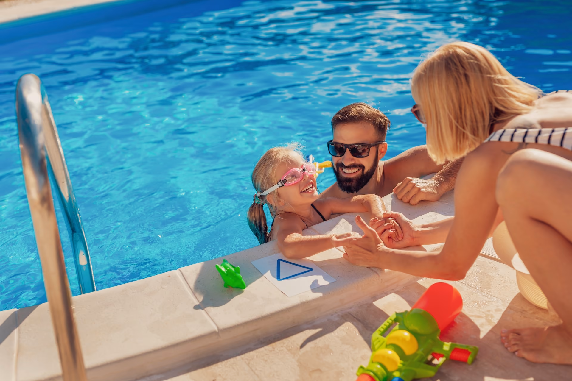 Parents playing in pool with child